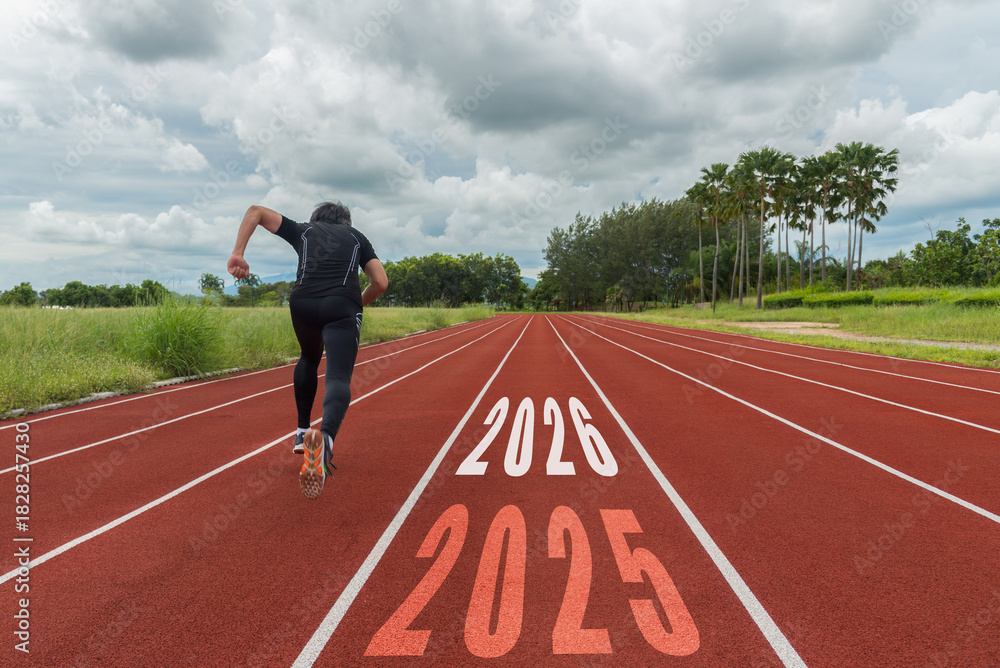 Fototapeta premium The start into the new year 2026. Start up of runner man running on nature race track go to Goal of Success. People running as part of Number 2025. Holiday sport and health care Concept