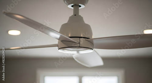 Modern white ceiling fan circulating air and providing light in a bright minimalist interior for home comfort concept and contemporary design