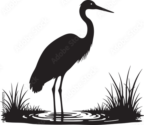 Black silhouette of a heron standing in water with grass