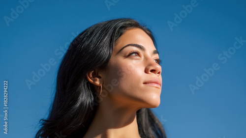 Wallpaper Mural Young latin woman, confident girl, female face under clear blue sky with warm sunlight, serene mood and natural beauty shine softly Torontodigital.ca
