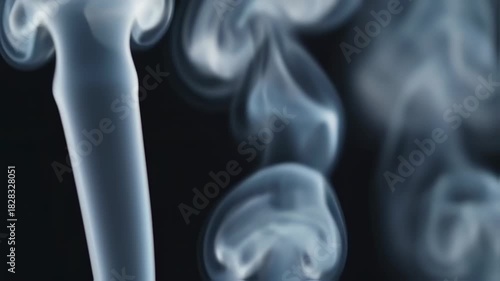 Captivating slow motion smoke plumes against a dark background creating ethereal patterns