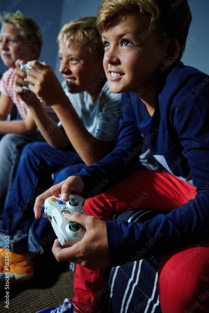 Obraz premium Video games, friends and teens on sofa in home for playing, competition and online entertainment. Challenge, living room and boys with controller for gaming, esports and winning on weekend together