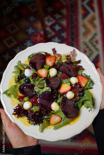 salad of eggs, meat, strawberries, raspberries in your hands