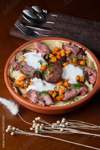 The Kazakh national dish Beshbarmak consists of boiled dough, meat and vegetables, sprinkled with sour cream.