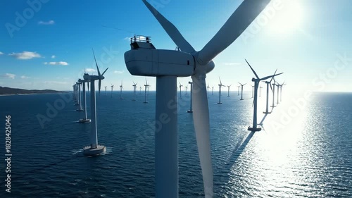 Seascape featuring a wind turbine farm under a bright sky with distant shore