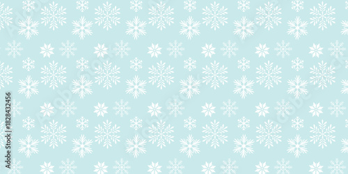 Seamless pattern with white snowflakes on a light blue winter background