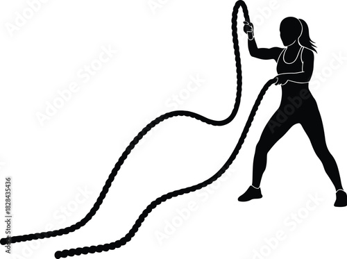 Silhouette of a woman exercising with battle ropes