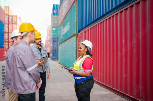 Photography A multicultural logistics team receives on-site instructions for container handling and freight movement, demonstrating teamwork and safety-focused workflow
