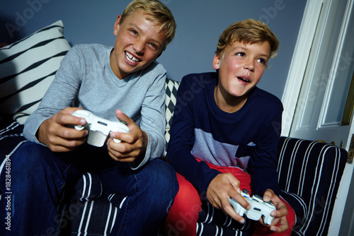 Obraz na płótnie Video game, competitive or sibling on sofa with controller, contest or playful challenge in multiplayer