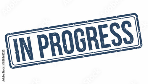 Creative concept of a weathered blue rubber stamp indicating an ongoing process, a work in progress for business communication and project management