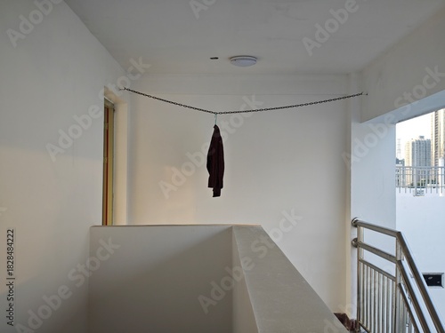 a vertical photo of a black jacket hanging on the clothes line