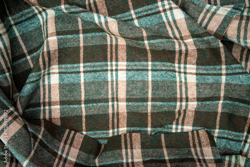 Woolen fabric in a cage. A photo of a green flannel fabric.