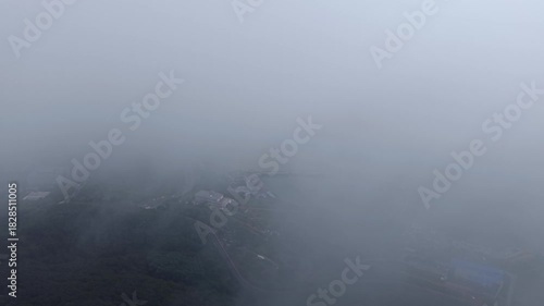 Dramatic foggy coastal city reveal with radar station, aerial China