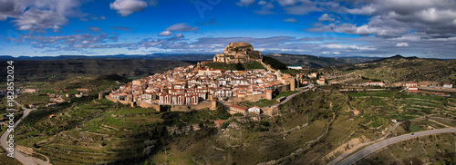 Morella, Spain medieval walled city and castle on a hilltop, surrounded by green landscape under blue sky