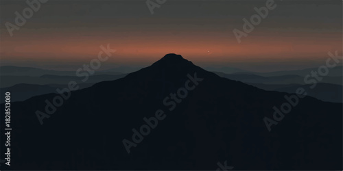 Silhouetted mountain peak at sunset with a dark and moody sky