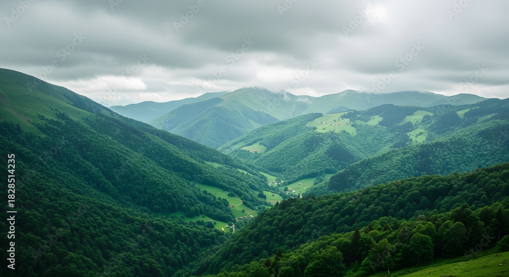 Fototapeta premium Vast, panoramic view of rolling green mountains under a dramatic, cloudy sky