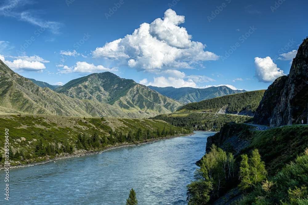 Fototapeta premium A river in the mountains on a clear sunny day. Road next to the water