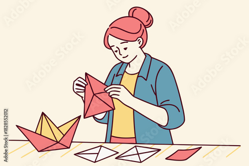 Woman creating origami art with folded paper on a table