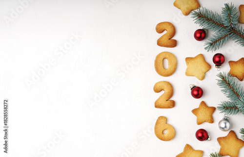 A cheerful holiday scene featuring cookies shaped into the digits 2026 on a white table, surrounded by evergreen sprigs and festive ornaments, perfect for Christmas, New Year
