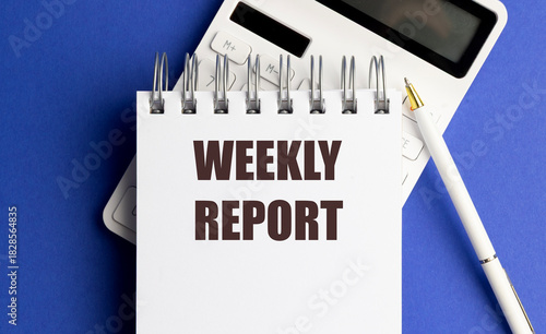 White spiral notebook with weekly report text, calculator and pen on blue background