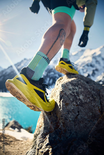 Man running at snow trail in the winter mountains