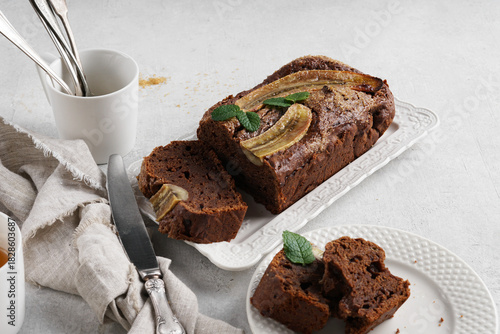 Homemade banana bread with dark chocolate close-up on table. Horizontal top view from above