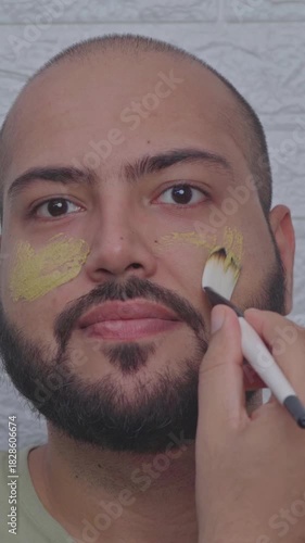 Vertical Video of Man Applying Clay Face Mask with Brush on Face