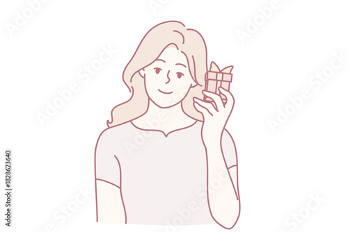 smiling woman savoring delightful chocolate bar, happy woman relishing tasty chocolate snack in casual surroundings, woman smiles joyfully while holding chocolate bar in relaxed environment