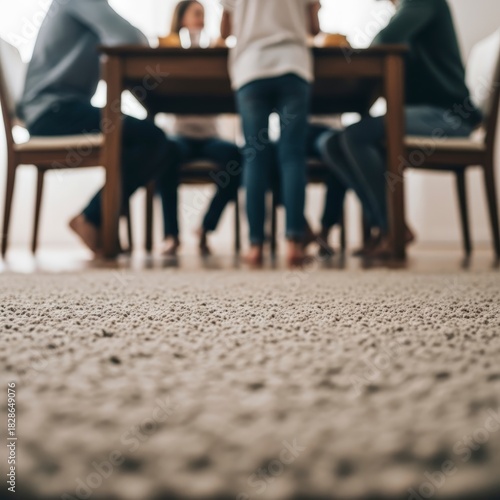 Cozy carpet foreground with blurred family dinner in background creating a warm domestic ambiance