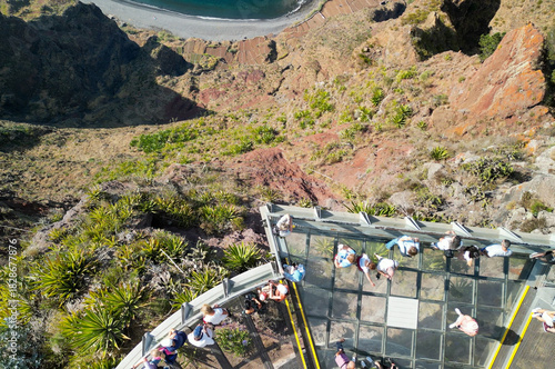 Tourists enjoy the viewpoint at Cabo Girao, along the Madeira coastline, Portugal. Aerial view from drone