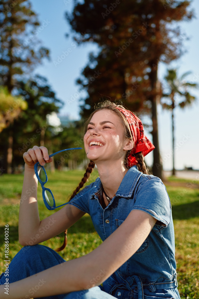 Naklejka premium Lifestyle woman in modern boho-western denim street style enjoys sunny outdoor moment with joyful smile, relaxed pose, and vibrant film color tones