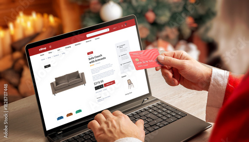Santa shopping online on laptop with credit card in cozy Christmas interior, perfect for ecommerce promotions, holiday marketing, winter retail and digital shopping themes