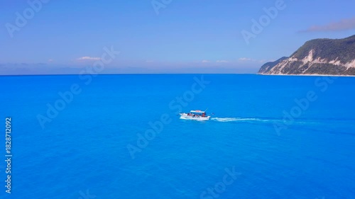 Lefkada, Greece - July 30th 2025 drone view tourist boat in greek sea with turquoise blue crystal clear water Ionian sea islands. Day trip boats in shallow sea on sunny day in summer. tracking boat