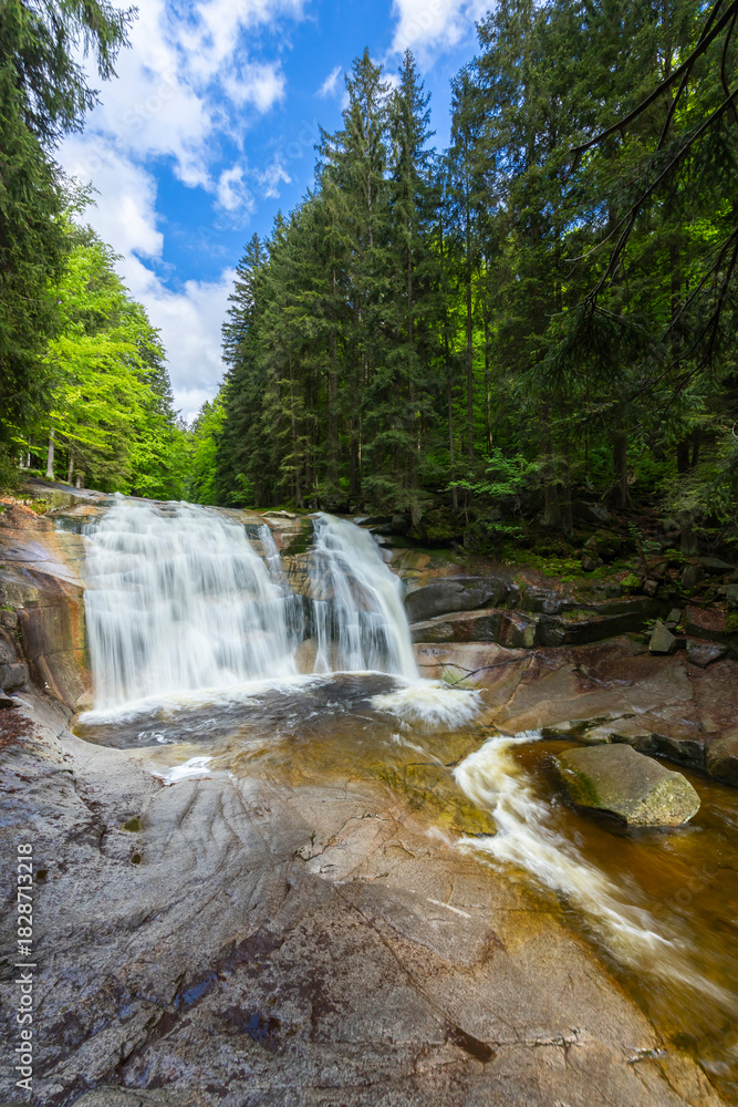 Obraz premium Water falling over rocks in Harrachov forest