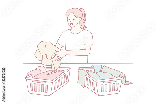 woman folding donated clothes at table, sorting items into baskets while focused and calm. soft pastel