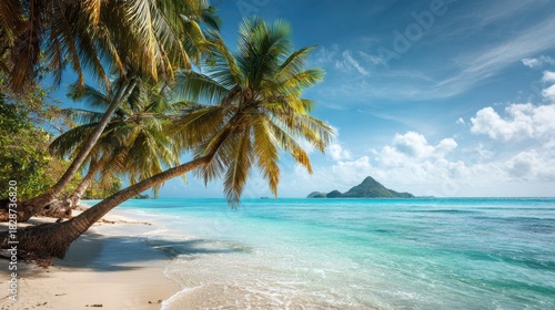 Bright sunlight reflects off the clear blue water at a tropical beach lined with swaying palm trees. A picturesque small island is visible offshore creating a tranquil paradise.