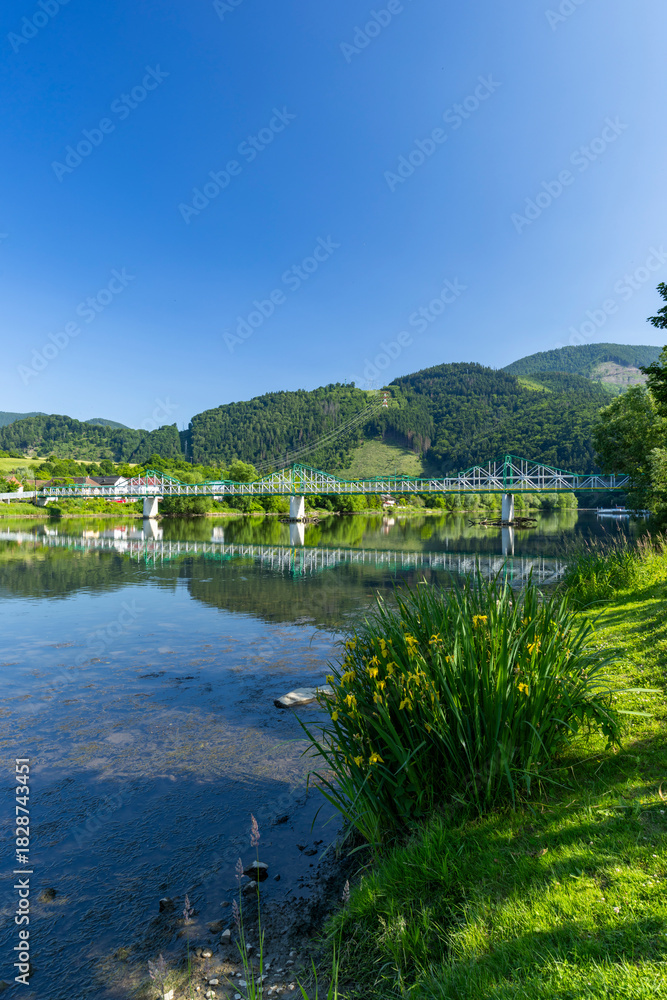 Obraz premium Green railway bridge crossing Vah river in Strecno, Slovakia