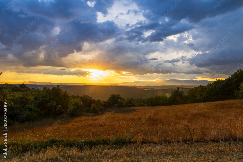Fototapeta premium Sunbeams piercing dramatic clouds over Provence landscape