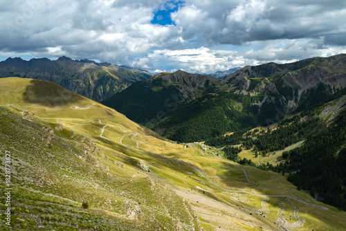 Winding road through French Alps valley with cloudy sky