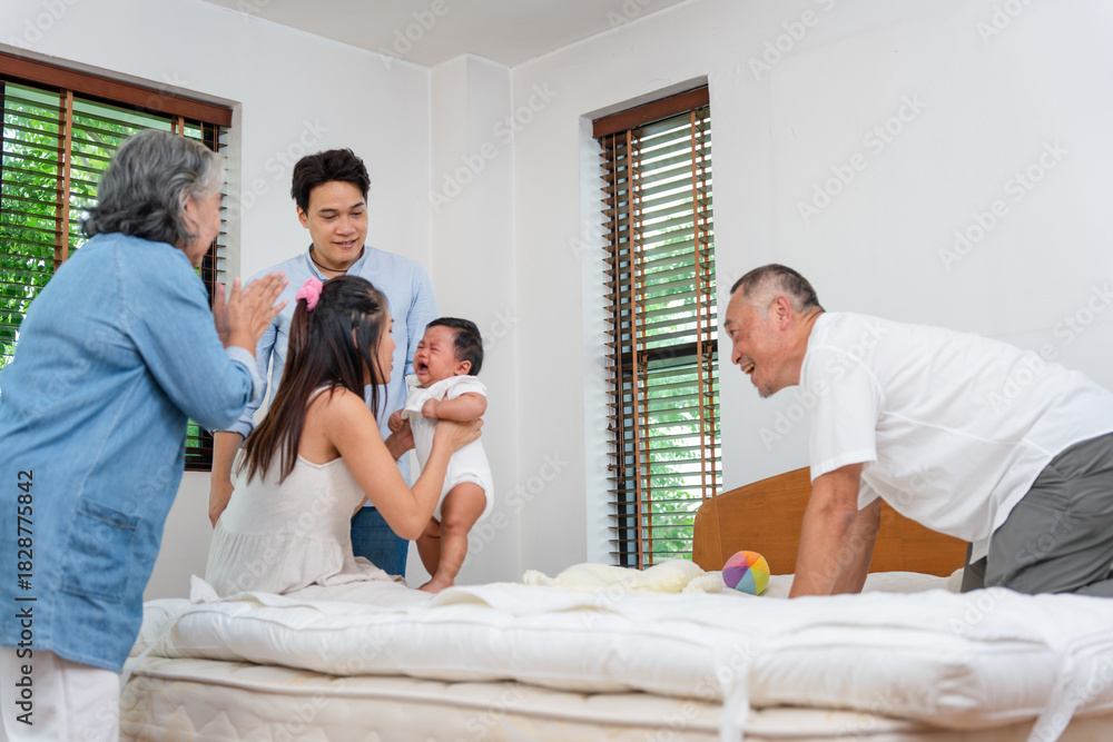 Fototapeta premium Asian multigenerational family comforting crying baby at home, Parents and grandparents supporting upset infant in bright bedroom, Family caring for crying newborn together in cozy home setting