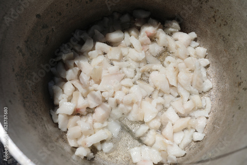 Cubed lard rendering in pot