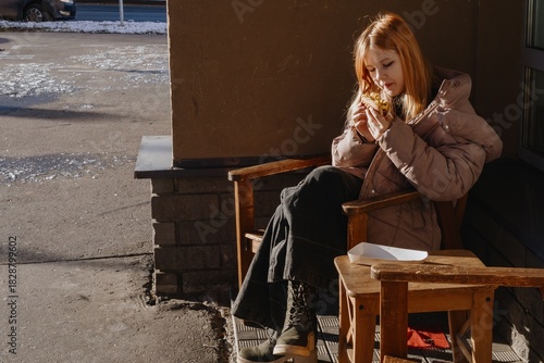 A 12-year-old teenage girl enjoys breakfast in a cozy cafe with fast food. Authentic moment of teen independence, urban lifestyle and casual dining