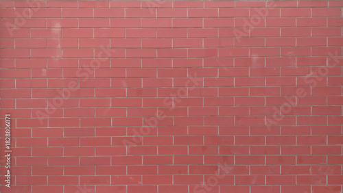 A brick wall with a red color. The wall is made of bricks and has a rough texture. 