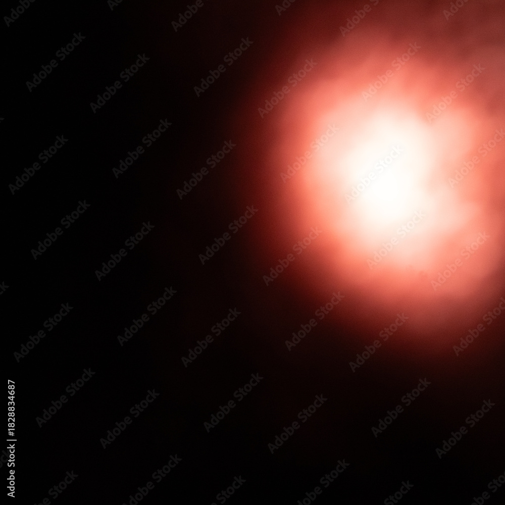 Obraz premium Abstract Dark Black Background with a Bright, Glowing Red Light Spot or Flare, Creating a Dramatic and Intense Effect