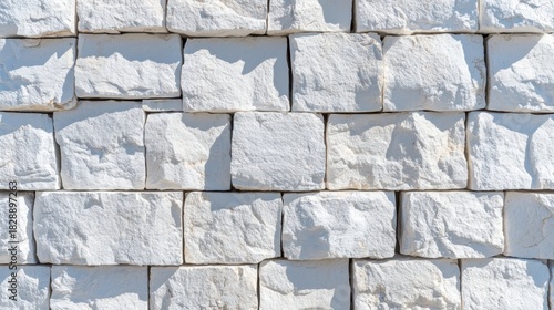 Textured White Stone Wall Background with Natural Sunlight and Shadows, Rough Surface Pattern of Stacked Rough-Cut Blocks