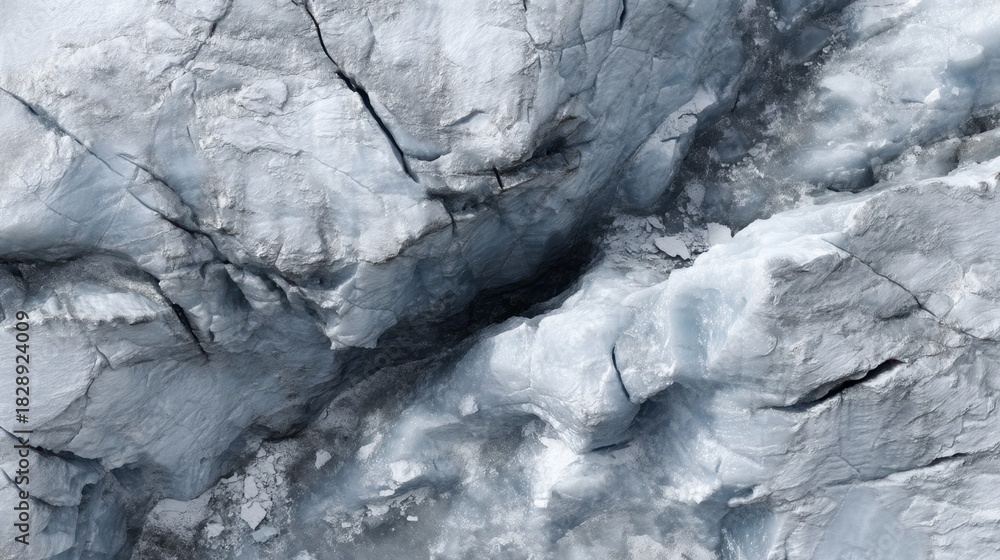 Fototapeta premium Detailed close-up of a rugged glacier surface showcasing unique textures and patterns of ice with cracks and crevices in varying shades of blue and gray
