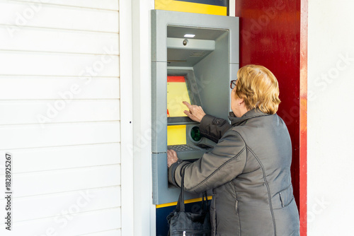 Photos Senior woman using the ATM