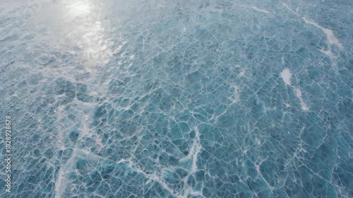 Aerial View of Cracked Ice Surface with Sunlight Reflection - Frozen Landscape