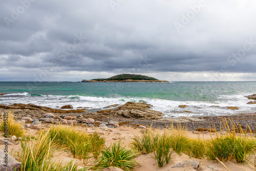 A captivating view of Ingonish Island from Wharf Road, Nova Scotia, showcasing the island's natural beauty and the rugged Atlantic coastline.