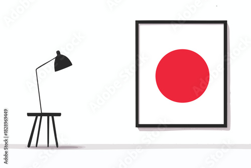 A minimalist interior design features a framed artwork displaying the Japanese flag alongside a modern black lamp and stool against a clean, white wall.